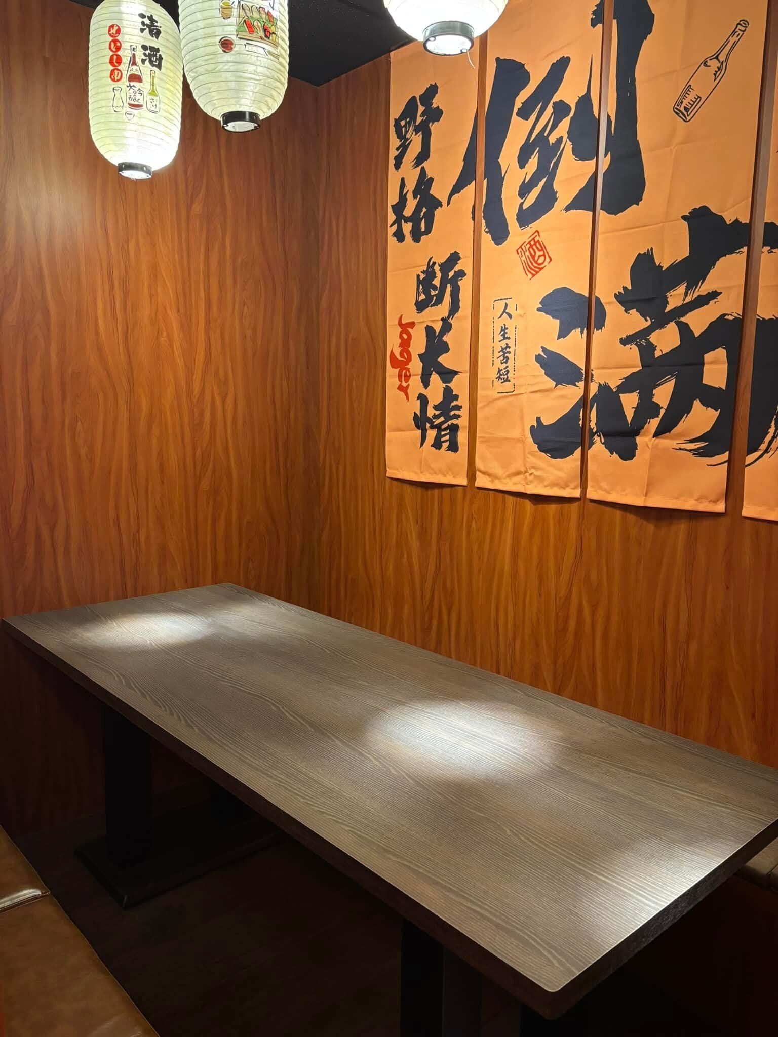 居酒屋室內空間,木質裝潢搭配日式書法掛軸,溫暖燈光